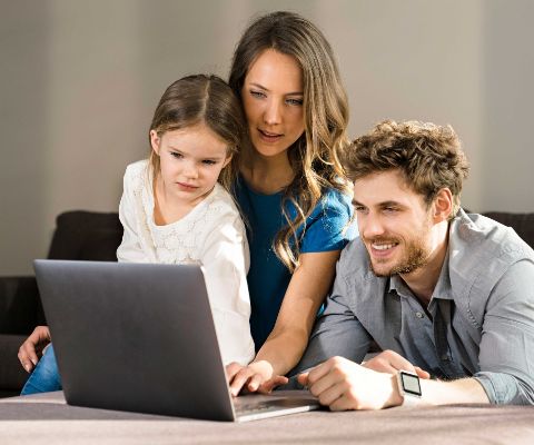 Les parents et leur fille regardent une tablette