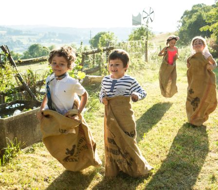 Des enfants font la course en sac