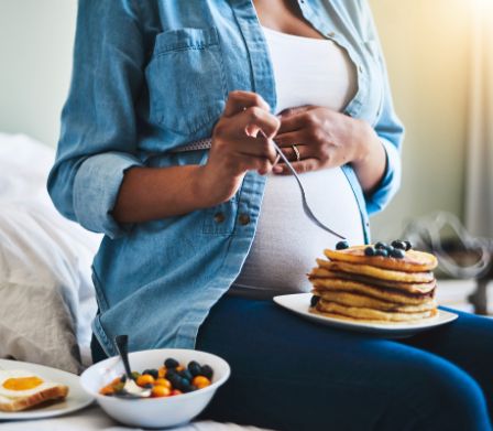 Femme enceinte en train de savourer des cornichons